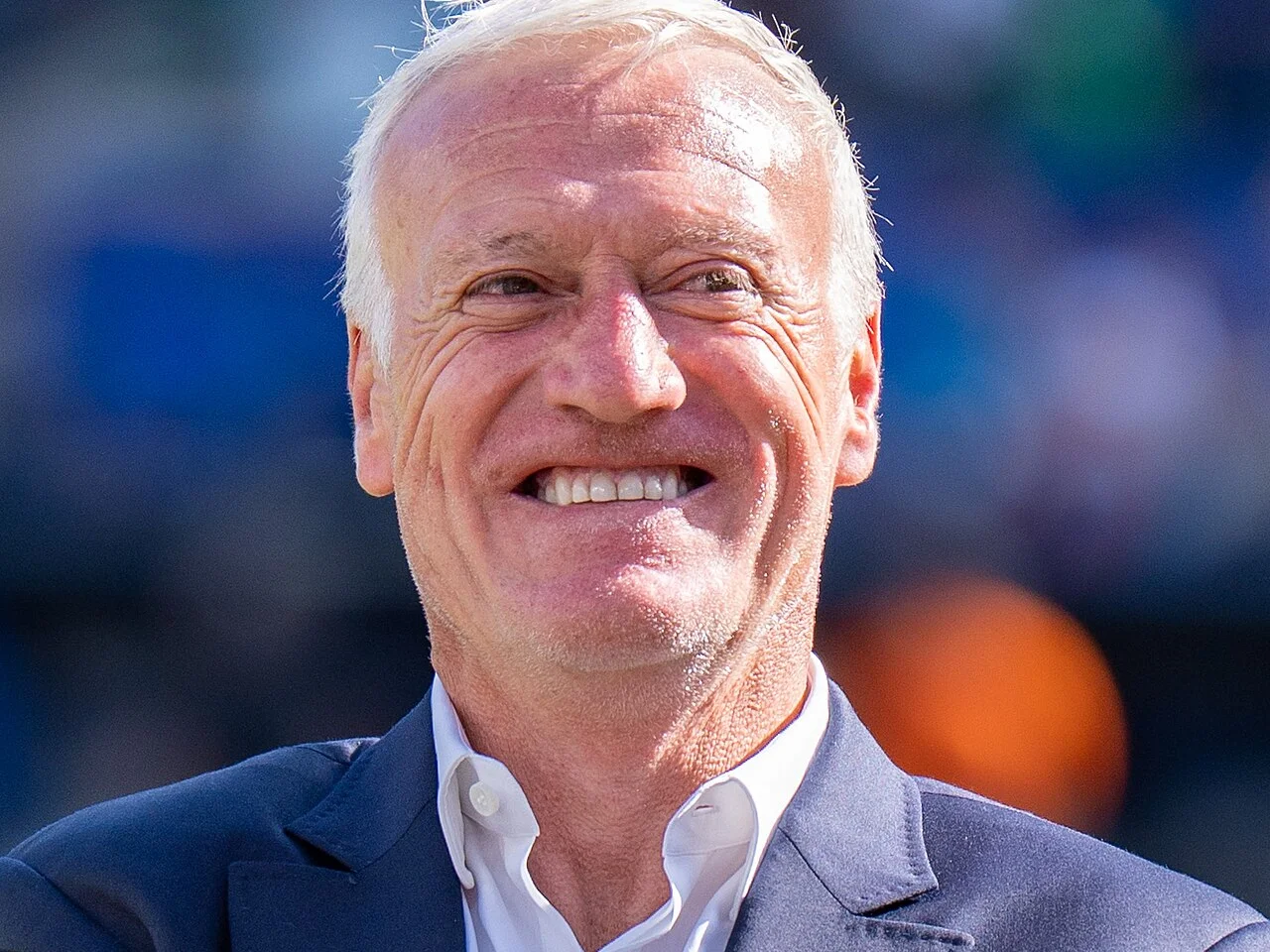 Didier Deschamps ler i mörkblå kavaj och vit skjorta under VM 2026